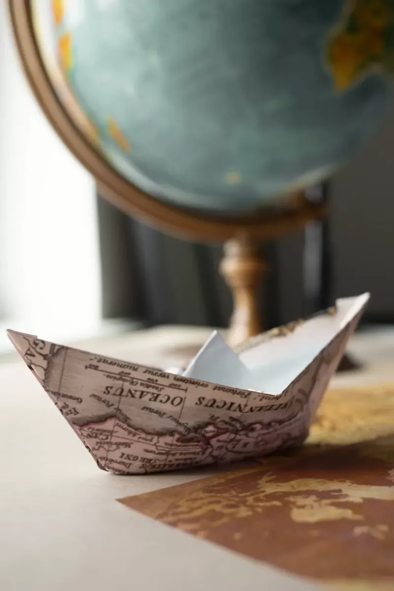 Paper boat next to a globe